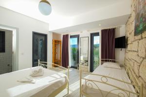 una camera da letto con due letti e un muro di pietra di Kybele Alaçatı a Smirne