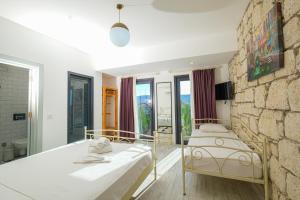 una camera da letto con due letti e un muro di pietra di Kybele Alaçatı a Smirne
