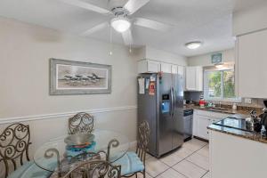 a kitchen with a refrigerator and a table and chairs at Waves 14 Condo Beautiful 1 Bedroom with Pool in St Pete Beach