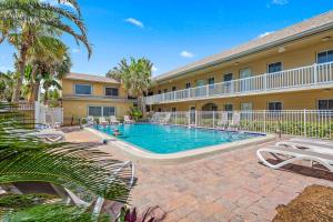 a swimming pool in front of a building at Waves 14 Condo Beautiful 1 Bedroom with Pool in St Pete Beach