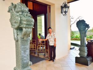 a man standing in the doorway of a building at Okinawa Kariyushi Resort EXES Onna in Onna