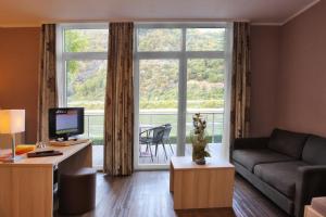uma sala de estar com um sofá e uma grande janela em Hotel Rheinkönig em Kamp-Bornhofen