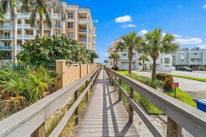 Un paseo marítimo que conduce a una pasarela con palmeras y condominios. en Rock Lobster 2 Private Bungalow Duplex with, en St Pete Beach 18 fotos más