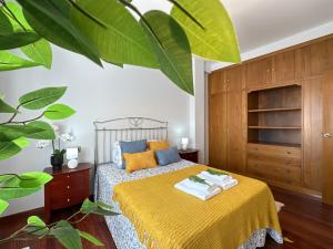 1 dormitorio con 1 cama con manta amarilla en Lux Plaza Cambados, en Cambados