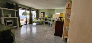 a kitchen with a living room with a table and a fireplace at La Ranita 2 EMPIREO in La Asomada