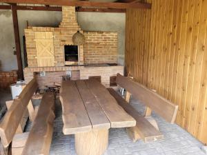 a wooden table with benches in front of a brick oven at Twój wypoczynek in Augustów