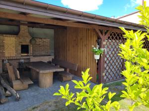 a patio with a wooden table and a bench at Twój wypoczynek in Augustów
