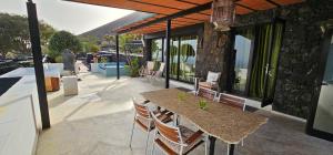 a patio with a table and chairs on a house at La Ranita 2 EMPIREO in La Asomada
