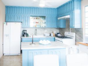 a blue kitchen with white appliances and blue cabinets at 2-Bedroom House in Rincon in Rincon