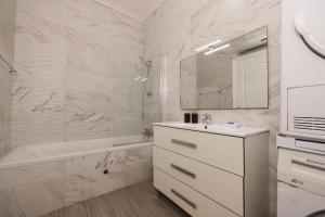 y baño blanco con lavabo, bañera y lavamanos. en Morning Breeze, en Is-Swieqi