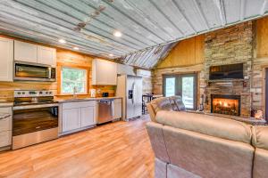 cocina y sala de estar con sofá y chimenea en Kentucky Cabin Retreat with Covered Porch and Views, en Lewisburg