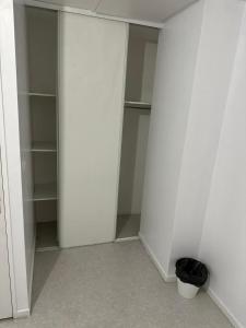 an empty closet with white walls and a bucket at Chambre meublée cuisine 20 minutes de Disneyland 2 in Champs-Sur-Marne +1 photo