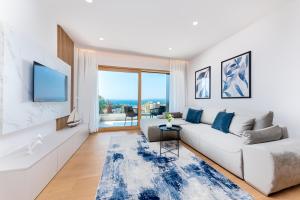 a living room with a white couch and a large window at Luxury Adria Sea City & Whirpool, Mountain View Apartment in Makarska
