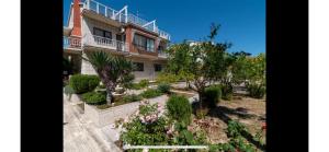 ein Haus mit einem Garten davor in der Unterkunft Villa Pantana Beach in Trogir + 29 Fotos