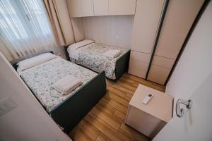 two beds in a small room with a table at Villa Capri in Campofelice di Roccella +62 photos