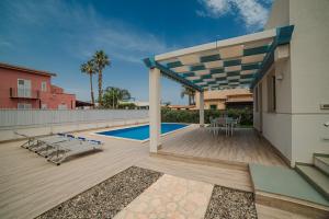 a patio with a deck and a swimming pool at Villa Capri in Campofelice di Roccella