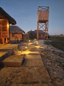 a pathway leading to a building with a tower at Vila Ronquinha - Arpoador in Tutóia