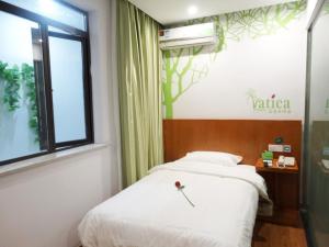 1 dormitorio con cama blanca y ventana en Vatica Shanghai JiaDing District AnTing Metro Station MoYu Road Hotel, en Jiading