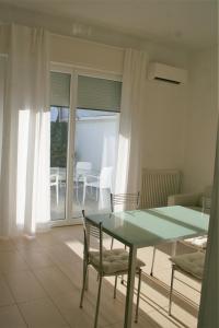 een eetkamer met een groene tafel en stoelen bij Case VacanzeRò in Ravenna