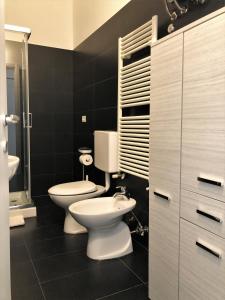 een badkamer met twee toiletten en een wastafel bij Case VacanzeRò in Ravenna