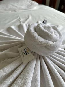 a white towel laying on top of a bed at Hotel Brasil Real in Mariana