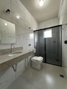 a bathroom with a toilet and a sink and a shower at Hotel Brasil Real in Mariana +28 photos