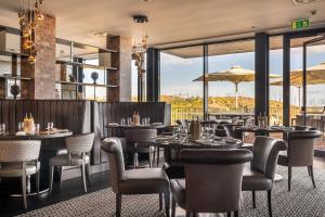 Un restaurante con mesas, sillas y ventanas. en Monchique Resort & Spa, en Monchique
