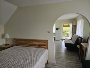 a bedroom with a bed and a living room at Namiņš ar balkonu in Jelgava