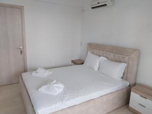 a white bed with two white towels on it at La Mer Krioneri beach in Parga