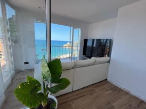 - un salon avec un canapé blanc et de grandes fenêtres dans l'établissement Las Vistas Faro de Cullera, Valencia, à Faro de Cullera
