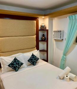 a bedroom with a white bed with blue curtains at Tagum Mini Hotel By Tripleview residences in Tagum
