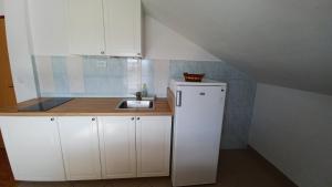 una piccola cucina con armadi bianchi e lavandino di Apartments Darija a Sveti Petar