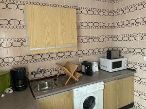 a kitchen with a sink and a washing machine at Pisos Isla Cristina 1 in Isla Cristina