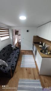 ein Wohnzimmer mit Couch und Küche in der Unterkunft ZEMAN Old Town Apartment in Sarajevo