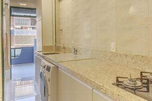 a bathroom with a sink and a washing machine at Apto em condomínio Pé na Areia em Itapema N1672 in Itapema +30 photos