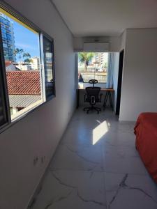a living room with a large window and a table at 11suites casa Suite#1 in Caraguatatuba
