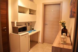 a small kitchen with a microwave on a refrigerator at Targura Lodging in Tarxien +10 photos