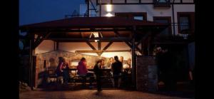 a group of people sitting under a gazebo at night at Stanica Wodna in Chmielno