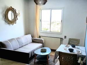 a living room with a couch and a table at Studio très haut standing avec vue dégagée in Tunis