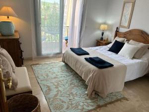 a bedroom with a large bed with blue pillows on it at Spacious duplex apartment families and couples in Manilva +23 photos
