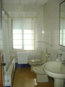 Un baño con dos inodoros, un lavabo y una bañera. en Hotel Rural Puerto Mágina, en Torres
