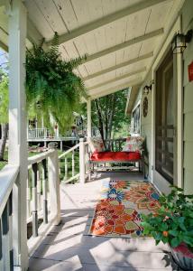 un porche avec un banc rouge et un tapis dans l'établissement Sara's Cottage, à Eureka Springs