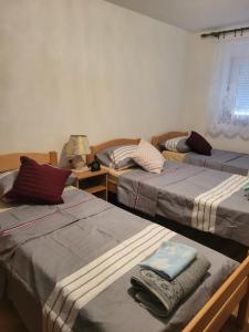 ein Zimmer mit 3 Betten und Handtüchern darauf in der Unterkunft Apartment Anis in Mostar