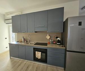 a kitchen with gray cabinets and a stainless steel refrigerator at Lake View in Meina +14 photos