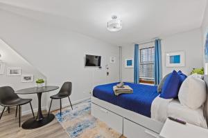 a bedroom with a bed and a table and chairs at Highly Recommended Studio Near Times Square in New York