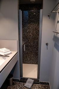 a shower with a glass door in a bathroom at Barak de Vinck in Ypres
