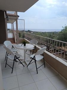 a patio with a table and chairs on a balcony at Olive & Garden in Nea Moudania