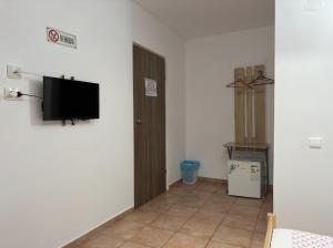Una habitación con un televisor de pantalla plana en una pared. en Casa FM, en Vama Veche