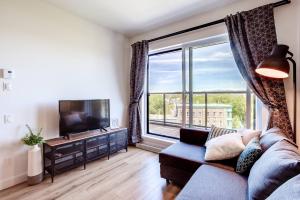 a living room with a couch and a large window at Sommet de la basse ville in Quebec City