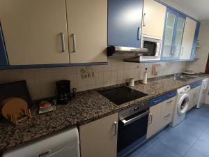 a kitchen with blue cabinets and a sink and a dishwasher at Apartamento Moni in Benia de Onís